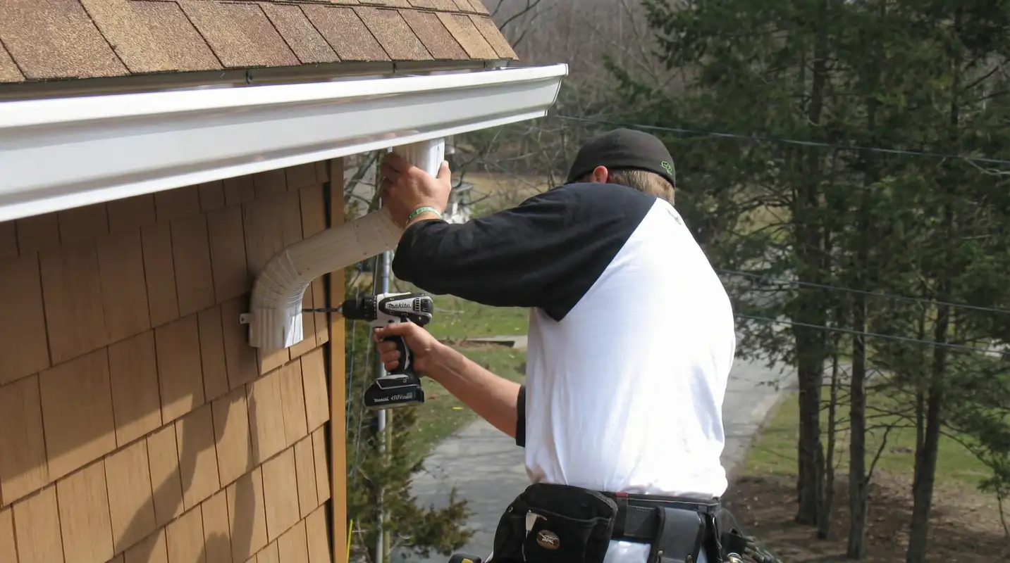 Professional contractor installing tan vinyl siding panels on a residential home exterior in Savannah, GA